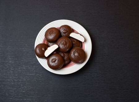 marshmallows in chocolate, sweets on a background with a mug of coffeeの写真素材