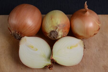 chopped onions with a knife on a cutting board on a black backgroundの写真素材