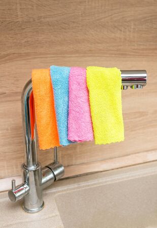cleaning the house in the kitchen, cleaning the faucet with a rag and cleaning agentの写真素材