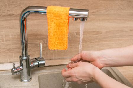 cleaning the house in the kitchen, cleaning the faucet with a rag and cleaning agentの写真素材