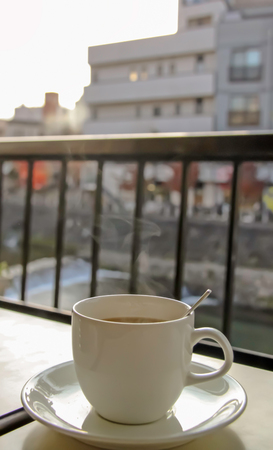 Steaming cup of coffee in the balconyの写真素材