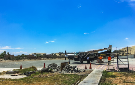 Ica, Peru - Jan 2015: A Cessna Grand Caravan single-engined turboprop airplane at Las Dunas Airport. Ground crew preparing plane for take off. Pilot doing his last inspectionsのeditorial素材