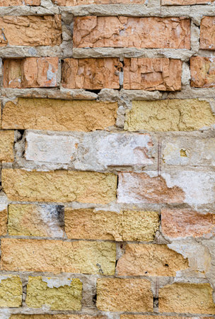 Battered old brick wall with cement. Rough bricklaying texture. Destroyed brickwork.の写真素材