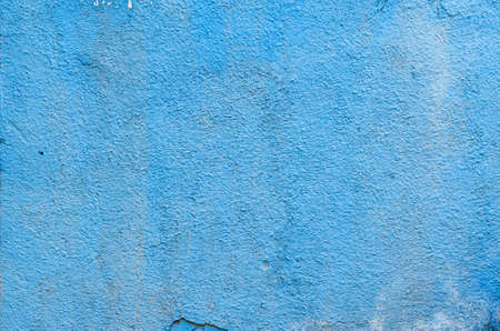 Blue paint dirty plaster wall texture. Texture of rough surface of old wall with cracksの写真素材