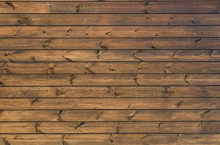 Stained wooden planks wall texture. Weathered wooden background. Natural wooden planks with knots at sunlightの写真素材