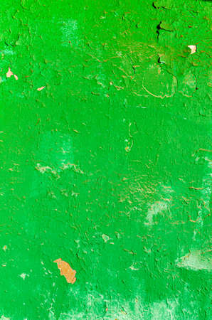 Green peeling dirty paint background. Texture of rough surface of old wall with a cracks, patterns and stainsの写真素材