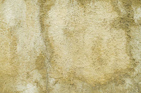 Brown plaster wet cracked background. Texture of rough surface of old wall with a cracks, patterns and stainsの写真素材