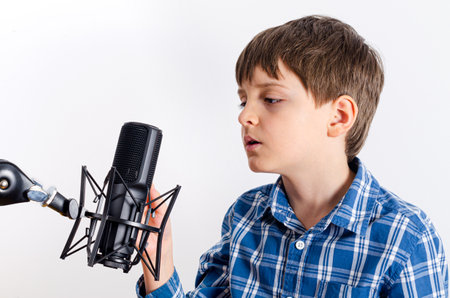 Kid in plaid shirt is speaking in microphone close up isolated on white background.の写真素材