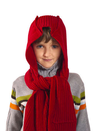 Portrait of a boy is wearing in red knitted cap and grey sweator looking at camera with smile on the white background. Cute boy is posing and looking cool. Winter concept.の写真素材