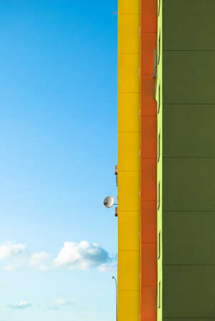 Multi-storey building painted in different colors. Colored walls and small satellite dish. Bright residential building for a beautiful life.の写真素材