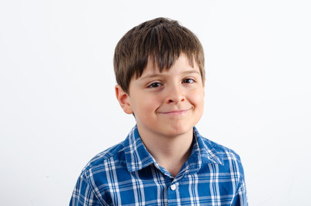 Portrait of a handsome smiling boy is wearing plaid shirt close up isolated on white background. Kid looking at the camera.の写真素材