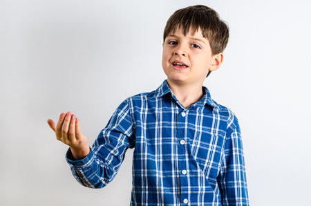 Portrait of cute boy holding nothing - side view. Happy kid with empty palm up - profile, isolated over white background. Child stretched out his hands - advertising areaの写真素材