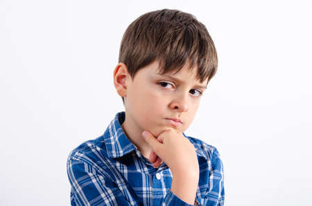 Handsome boy is wearing in blue plaid shirt thinking about something and puts his hand on the chin. Boy looking away isolated on white background.の写真素材