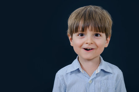 Portrait of a little boy looking straight ahead and smiling. Smart and tidy child on training in a...