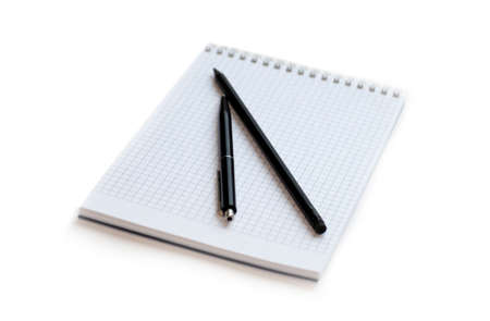 Pen and pencil lying on a notebookの写真素材