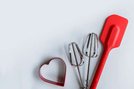 Baking supplies on white. Spatula, mixer whisks, cookie cutter on white backgroundの写真素材