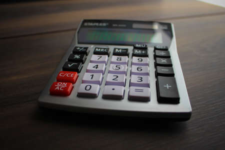 Calculator keypad on a wooden floor background. Top view. Copy spaceの写真素材