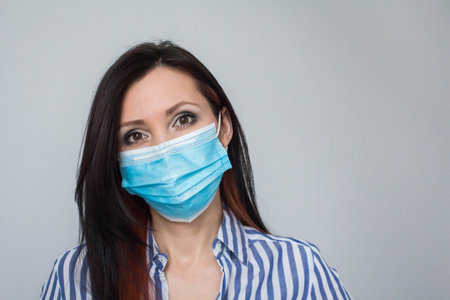 Close up portrait of beautiful young caucasian woman doctor nurse wearing protective mask virus prevention.の写真素材