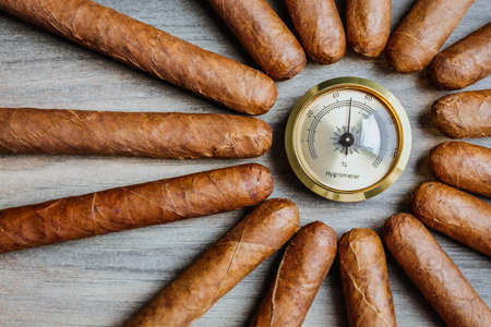 Cigars with humidor hygrometer on the wooden backgroundの写真素材