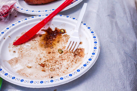 Empty dirty plastic plates with spoon on a white background. Ecology Concept for Earth Hour, Earth Day, Ocean Day and other ECO dates.の写真素材