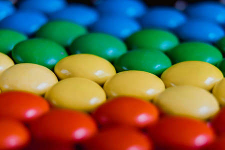 Rainbow of multicolored sweet candy dragees on isolated white background. Decorative Creative composition of round candy dragees in Rainbow colors. Concept Summer. Top view. Flat layの写真素材