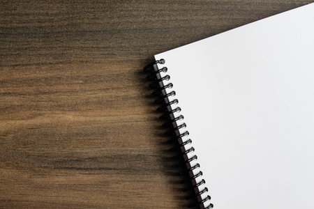 Spiral notepad paper on the wooden background. Empty. Space for text