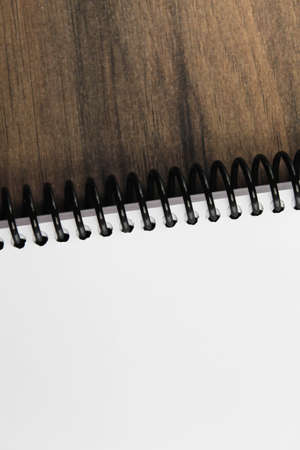 Spiral notepad paper on the wooden background. Vertical and space for textの写真素材