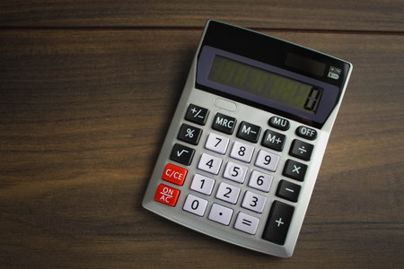 Top view photo of workplace with calculator on notebook on isolated wooden table background with copyspace. Business, coins, bitcoin conceptの写真素材