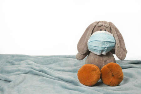 A sick plush toy in a mask. Flu colds disease virus bacterium. Plush donkey toy wear protection mask, Protect Against Coronavirus conceptの写真素材