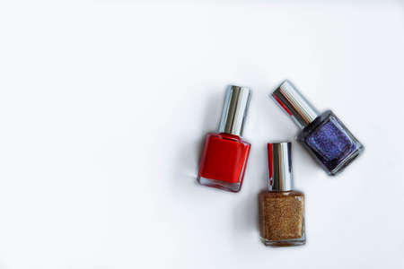 Colorful nail polish bottles on white. Red, gold, purpleの写真素材