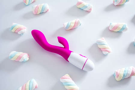 Pink dildo toy with pastel twisted marshmallows isolated on white background.の写真素材