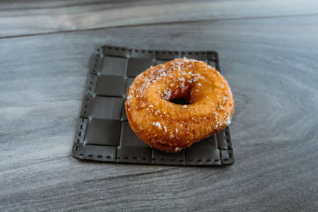 Sugar donut on a wooden backgroundの写真素材