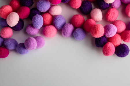 close up colorful pom poms texture background, heap of small pastel color fluffy ball for crafts and fashion accessories decoration, selective focusの写真素材