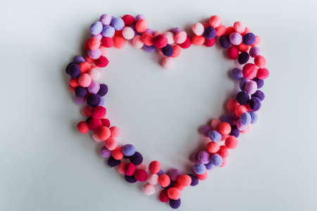 A beautiful big heart made of soft pom-poms against a light background. Heart love, love background, place for textの写真素材