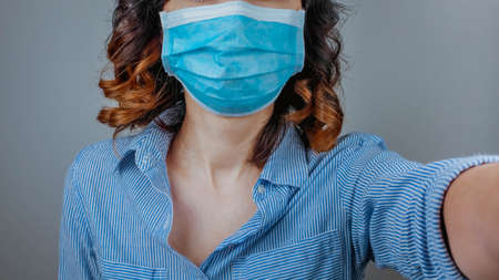 Woman wearing protection face mask against coronavirus. Medical mask, Surgical mask, Close up shot, Select focus, Prevention from covid19の写真素材