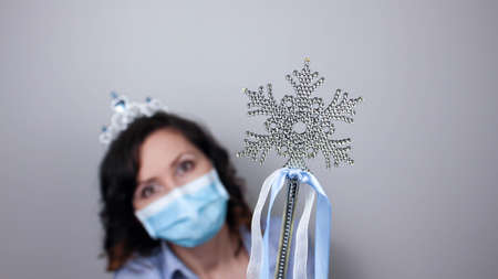 Woman wearing protection face mask against coronavirus. Woman in a mask and Christmas headband. Christmas, Halloween accessory. Medical mask, Close up shot, Select focus, Prevention from covid19の写真素材