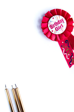 Pink birthday with golden candles. Happy birthday wishes for a girl on a pink badge on white backgroundの写真素材