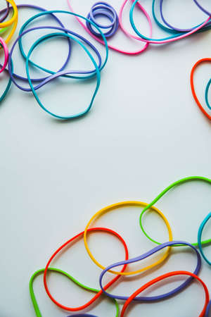 Top view of colorful rubber bands isolated on white. Rainbow elastic rubber bands on white. Space for textの写真素材