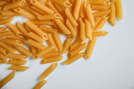 Raw macaroni on white. Dry noodles. Uncooked pasta. White backgroundの写真素材