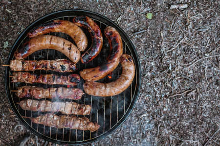 Barbeque meat and sausages on charcoal grill top viewの写真素材