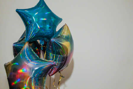 foil blue balloons filled with helium. holographic helium star balloons on white.の写真素材