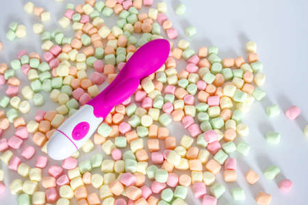 Pink dildo toy with pastel marshmallows isolated on white background.の写真素材