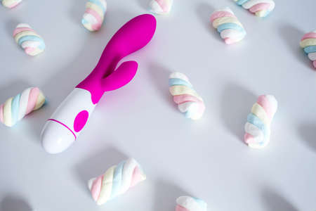Pink dildo toy with pastel twisted marshmallows isolated on white background.の写真素材