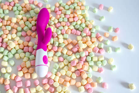 Pink dildo toy with pastel marshmallows isolated on white background.の写真素材