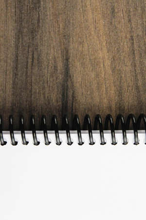 Spiral notepad paper on the wooden background. Vertical and space for textの写真素材