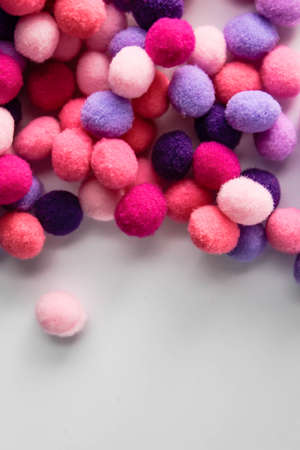 close up colorful pom poms texture background, heap of small pastel color fluffy ball for crafts and fashion accessories decoration, selective focusの写真素材