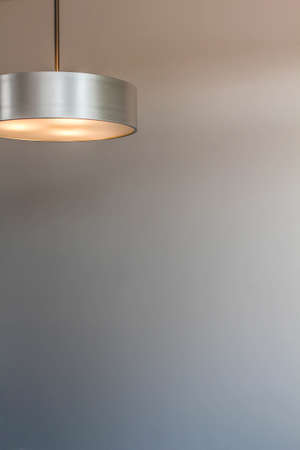 Glowing modern aluminum led lamp with white wall. Free space for text or design. Space for textの写真素材