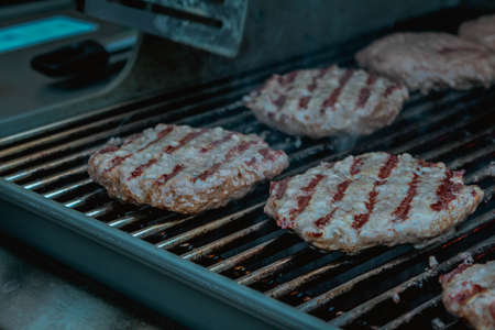 Smoky hamburger meat grilling for burgers. BBQ Grilled Burgers Patties.の写真素材