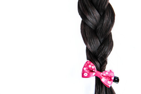 Black braided hair isolated on white background. Brunette natural braided hair extension on white backgroundの写真素材