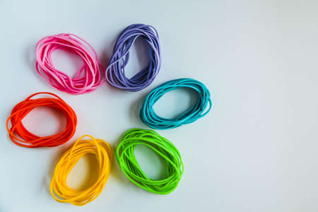 Top view of colorful rubber bands isolated on white. Rainbow elastic rubber bands on white.の写真素材